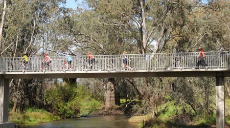 Cyclists and walkers crossing the river bridge at Axedale